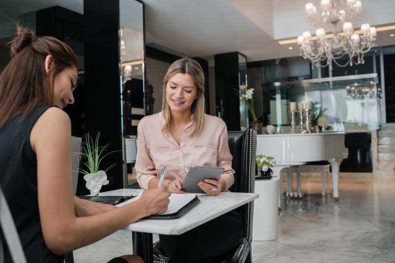 Cliente rubia en la recepción del salón de belleza leyendo las políticas del salón para citas y cancelaciones
