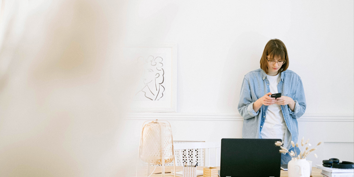 girl standing with phone sending professional email reschedule meeting