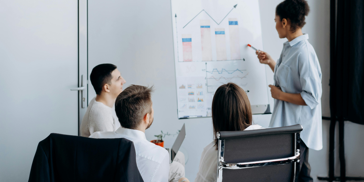 Colleagues enjoying improved meeting productivity while a female worker analyzes sales performance