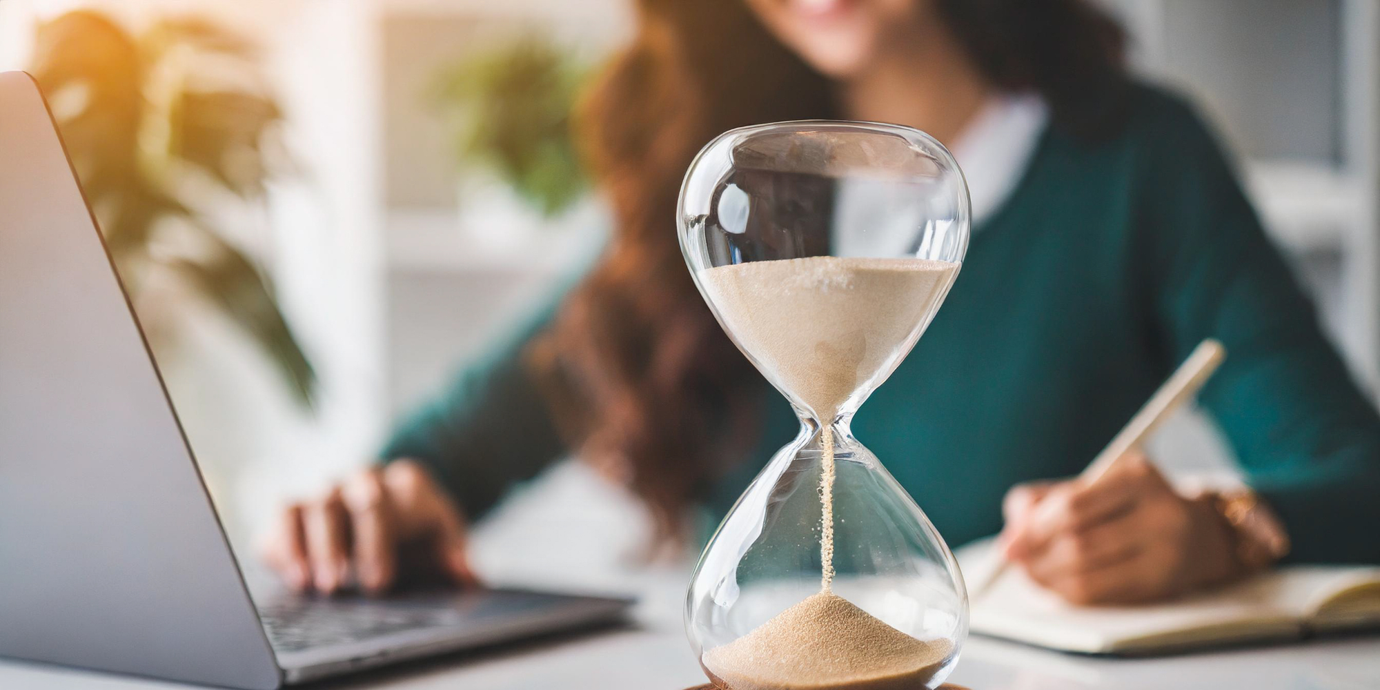 hourglass on desk as a visual for top time management apps to improve work-life balance.